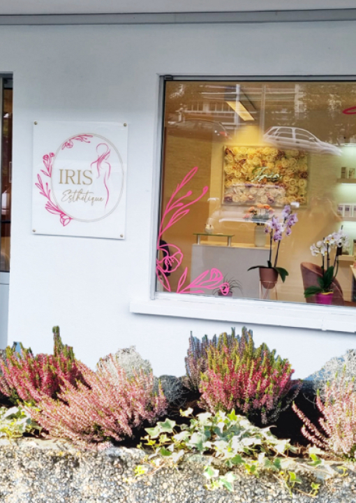 La vitrine fleurie de l'institut à Meyrin, avec son enseigne ovale et ses bruyères roses